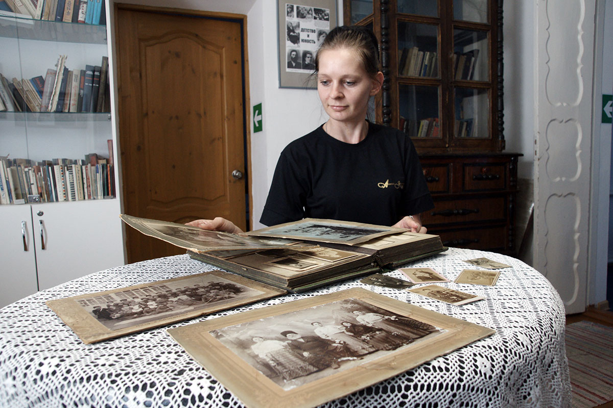 Яна Процко рассматривает в музее альбом со старыми фотографиями