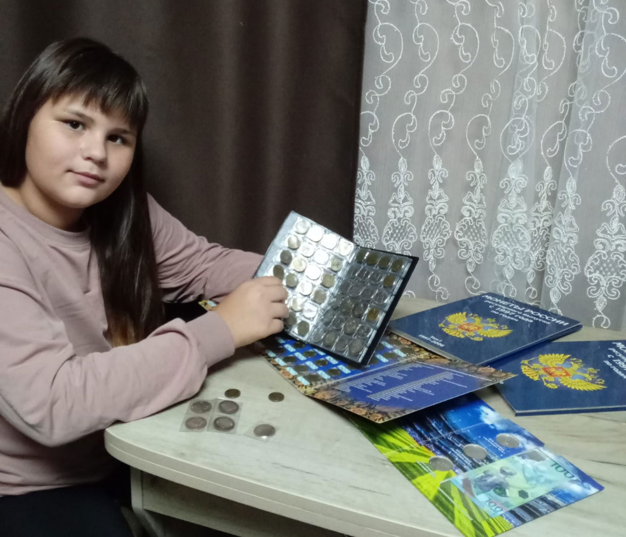 Дарина Воронова любит вечерами изучать родительскую коллекцию юбилейных монет. / Фото предоставлено М. Жилиной