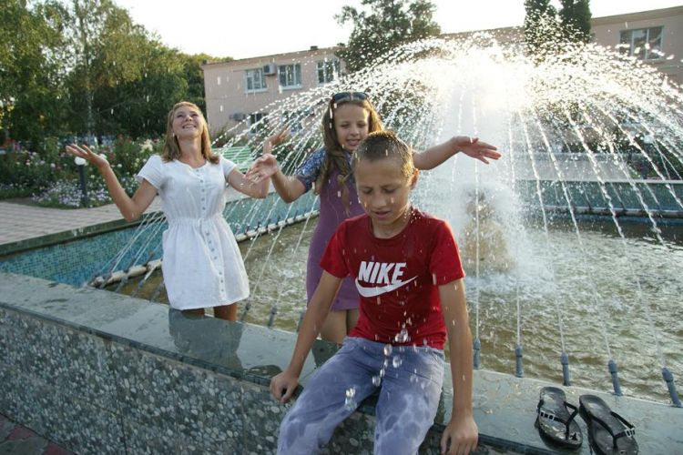 дети поселка сахарного завода с удовольствием охлаждаются под струями фонтана