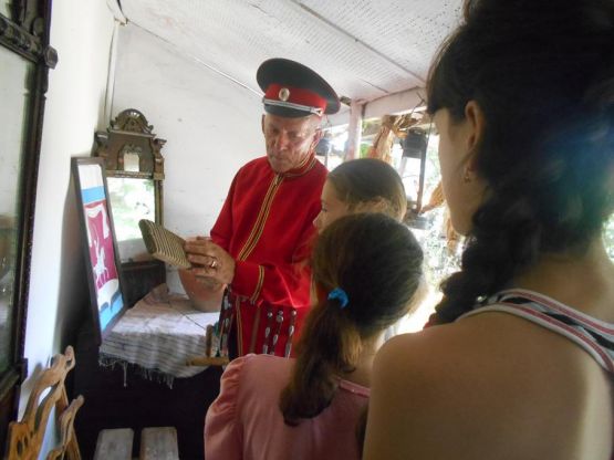 Николай Алексеевич Романчук демонстрирует детям предметы быта казаков