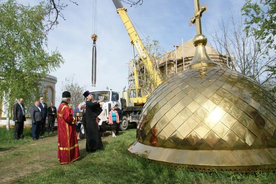 Отец Михаил  освящает крест и купол в строящемся  Свято-Георгиевском храме станицы Калниболотской